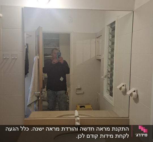 מראת קיר גדולה ללא מסגרת מותקנת מעל כיור בחדר רחצה